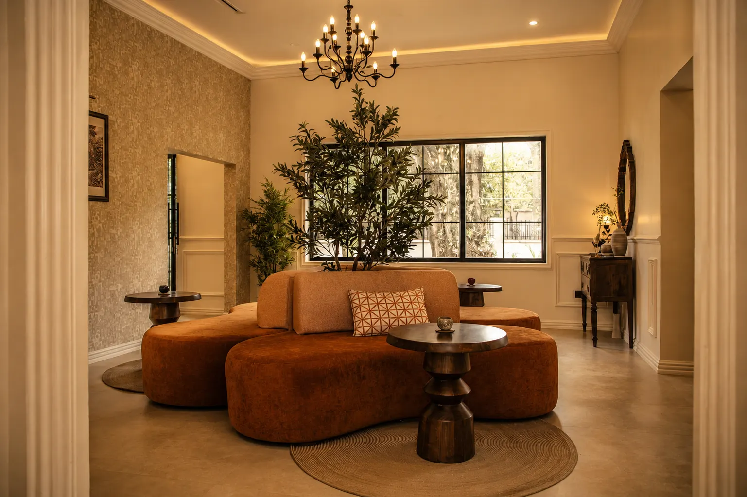 The lobby: a curved burnt-orange sofa under a wrought-iron chandelier.